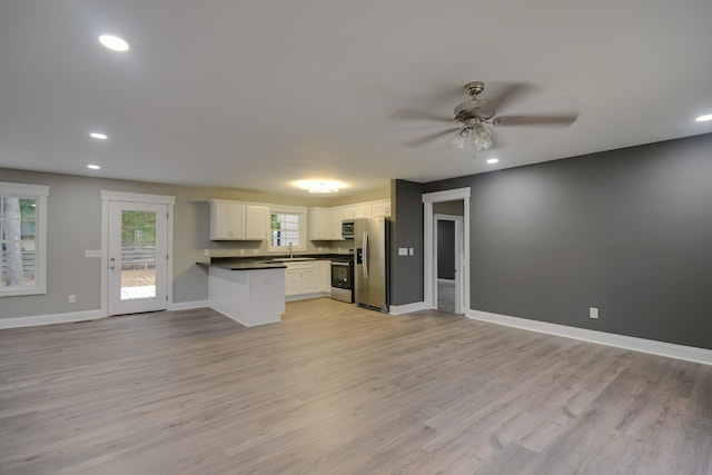 kitchen featuring ceiling fan, stainless steel appliances, white cabinets, sink, and light hardwood / wood-style floors