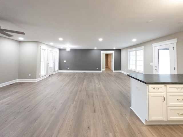 basement featuring ceiling fan and light hardwood / wood-style floors