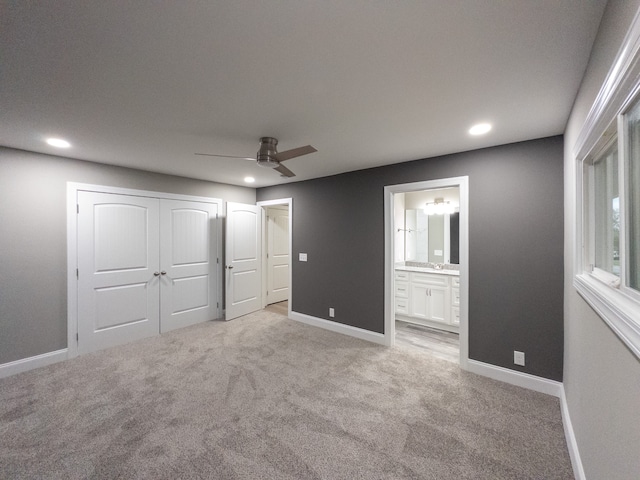 unfurnished bedroom with light carpet, ceiling fan, and connected bathroom