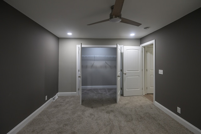 unfurnished bedroom featuring a closet, light colored carpet, and ceiling fan