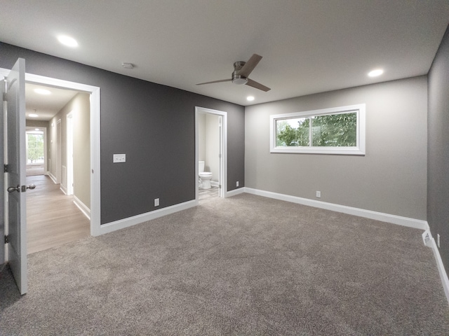 unfurnished bedroom featuring light carpet, multiple windows, and ceiling fan