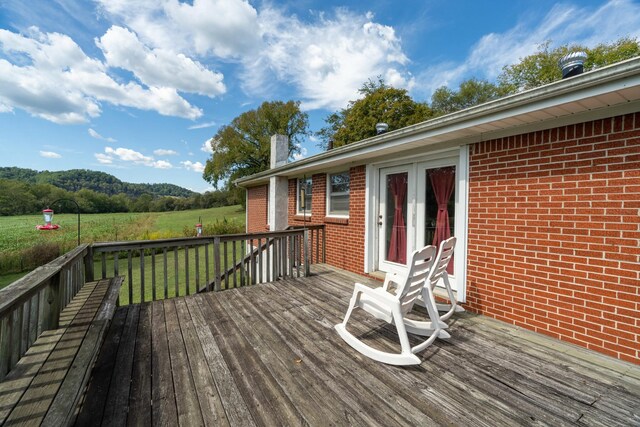 wooden deck with a lawn and french doors