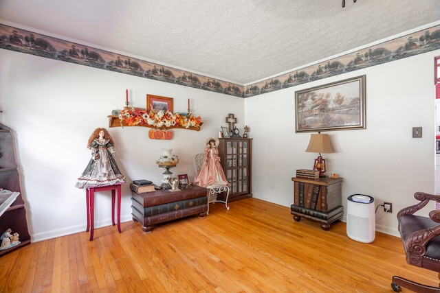 sitting room with a textured ceiling and hardwood / wood-style flooring