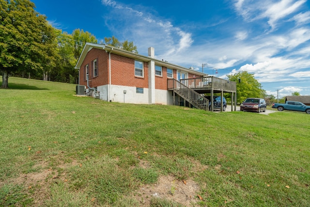 exterior space with central AC unit, a deck, and a yard