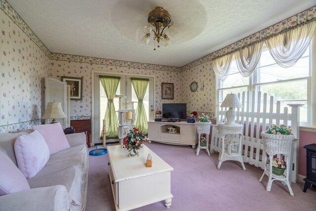 carpeted living room featuring a textured ceiling, a healthy amount of sunlight, and ceiling fan