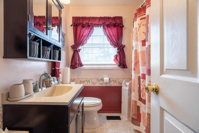 bathroom with tile patterned flooring, vanity, and toilet