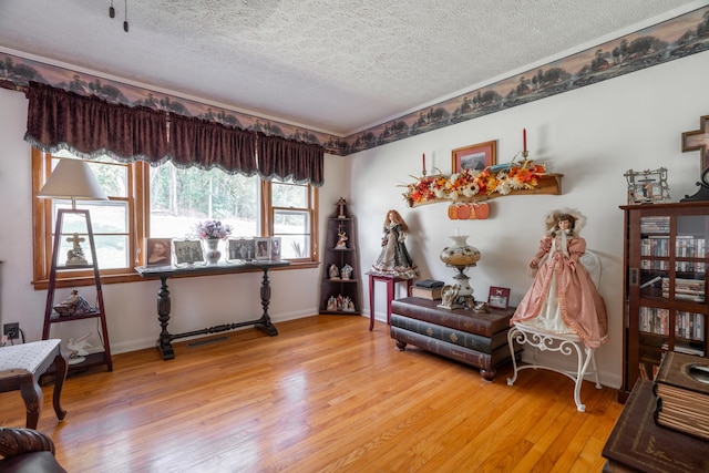 sitting room featuring light wood-type flooring and a textured ceiling