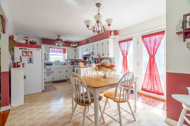 dining space featuring a chandelier and sink