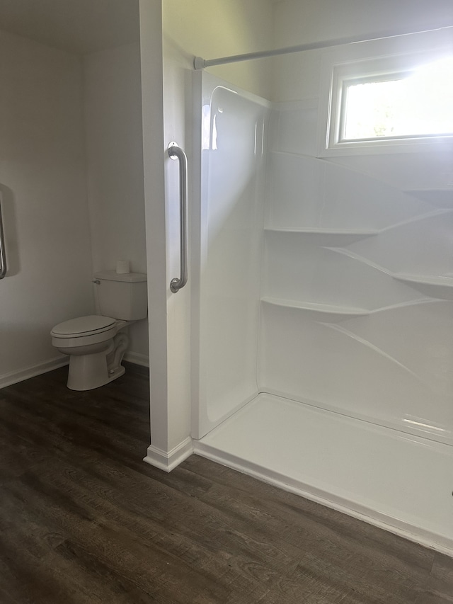 bathroom with a shower, toilet, and wood-type flooring