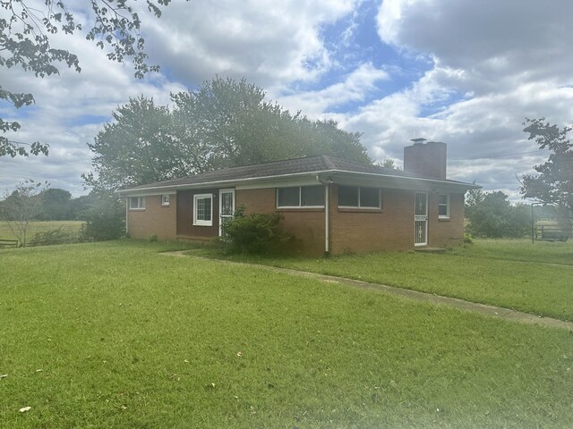 2550 Indian Mound Rd, Woodlawn, TN 37191 - view of front facade featuring brick siding, a front yard, and a chimney