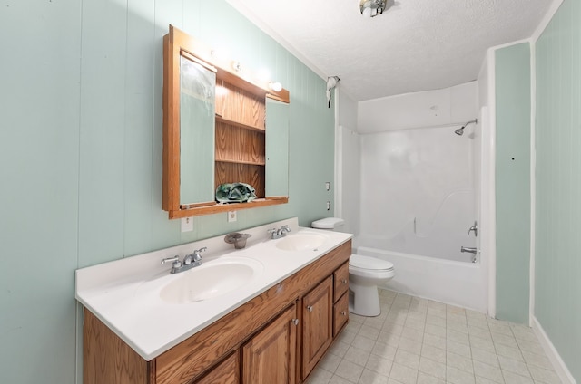 full bathroom with  shower combination, vanity, toilet, and a textured ceiling