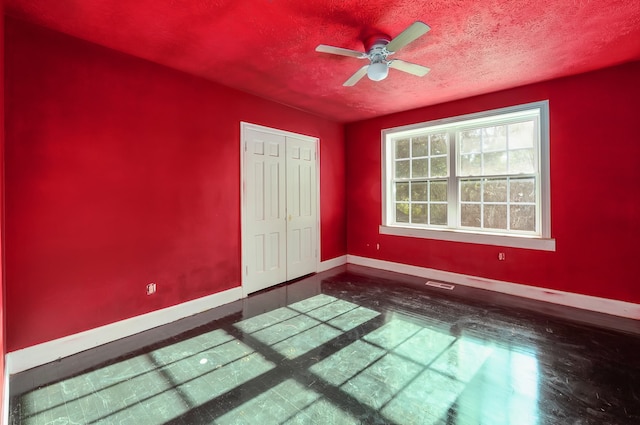 unfurnished room featuring ceiling fan and a textured ceiling