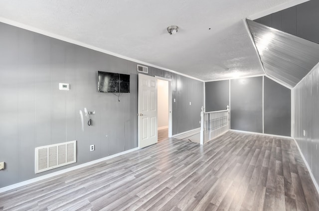 bonus room featuring light hardwood / wood-style flooring, lofted ceiling, and a textured ceiling