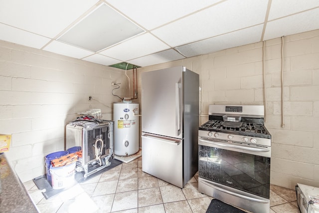 kitchen with appliances with stainless steel finishes, water heater, a drop ceiling, and light tile patterned floors