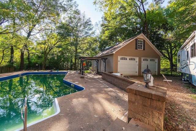 view of swimming pool featuring an outbuilding and a garage