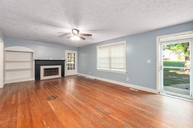 unfurnished living room with ceiling fan, a textured ceiling, and hardwood / wood-style floors