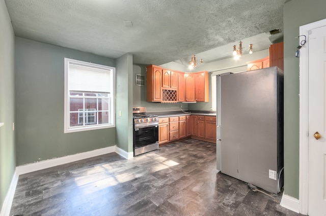 kitchen featuring a textured ceiling, stainless steel appliances, and dark hardwood / wood-style flooring