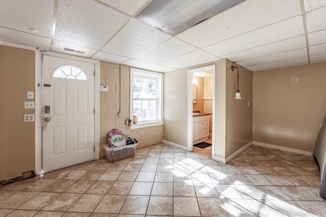 tiled entryway with a paneled ceiling and a healthy amount of sunlight