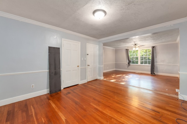 unfurnished room featuring a textured ceiling, ornamental molding, and hardwood / wood-style floors