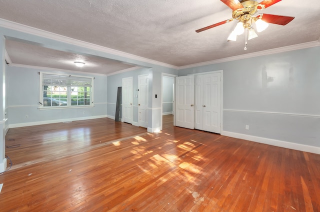 interior space with a textured ceiling, ornamental molding, ceiling fan, and hardwood / wood-style flooring