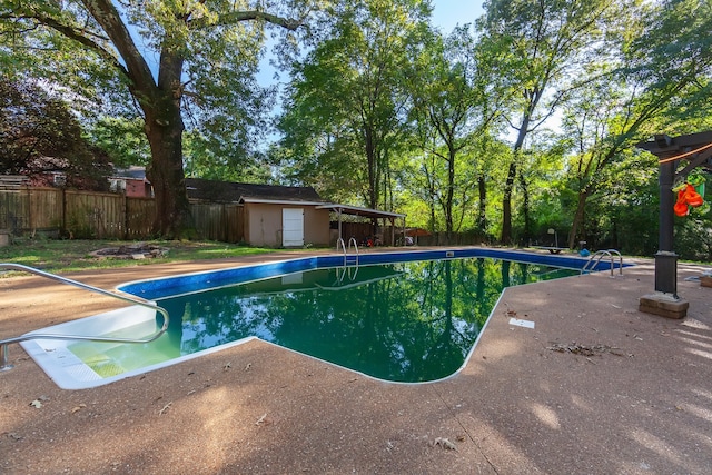 view of pool with a storage shed and a patio area