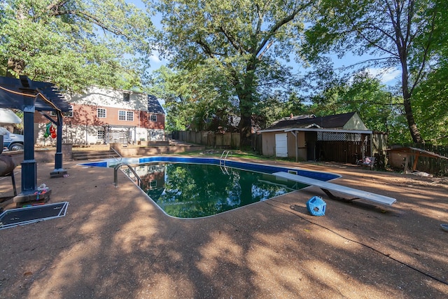 view of pool with a diving board and a storage unit