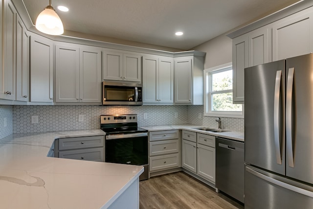 kitchen featuring backsplash, sink, pendant lighting, and stainless steel appliances