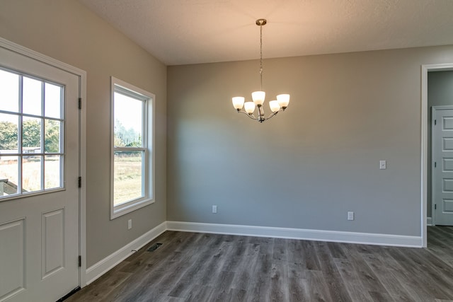 interior space featuring a notable chandelier, dark hardwood / wood-style floors, and plenty of natural light