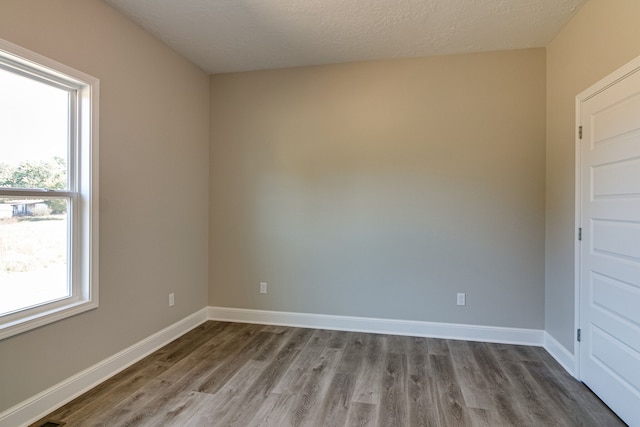 spare room with wood-type flooring and a textured ceiling