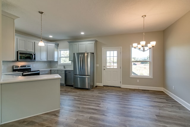 kitchen featuring pendant lighting, stainless steel appliances, and plenty of natural light