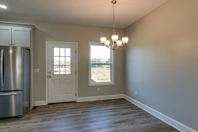 doorway to outside with a chandelier, a textured ceiling, and hardwood / wood-style flooring