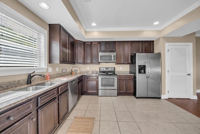 kitchen with crown molding, sink, light tile patterned floors, and appliances with stainless steel finishes