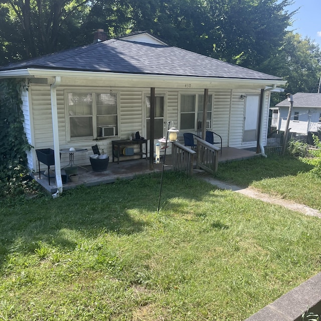 back of property with a lawn and a patio area