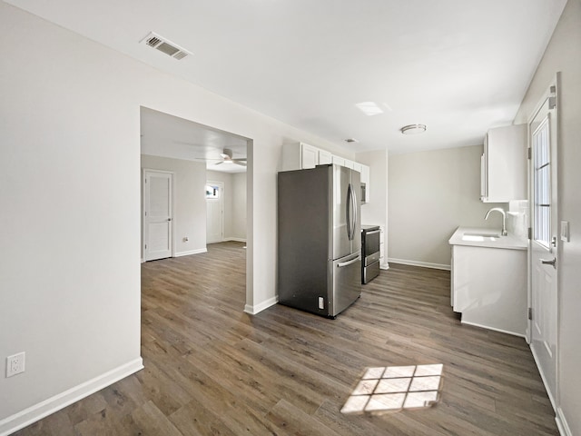 kitchen featuring stainless steel appliances, white cabinetry, ceiling fan, and dark hardwood / wood-style flooring