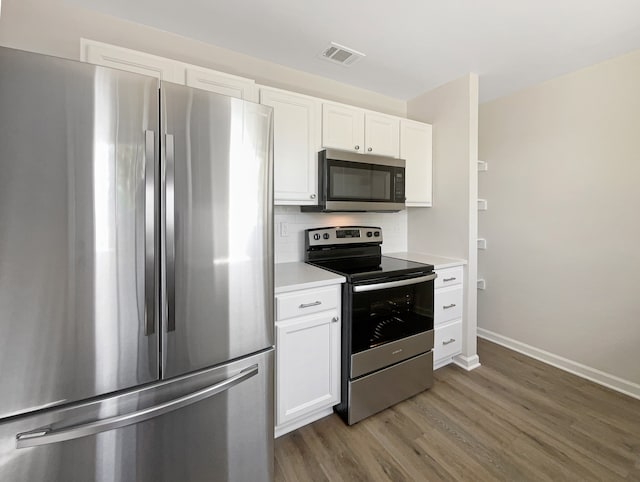 kitchen with white cabinets, stainless steel appliances, backsplash, and dark hardwood / wood-style flooring