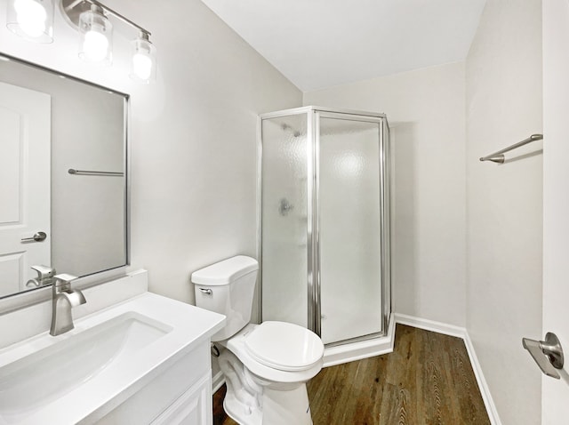 bathroom with a shower with door, toilet, vanity, and hardwood / wood-style flooring