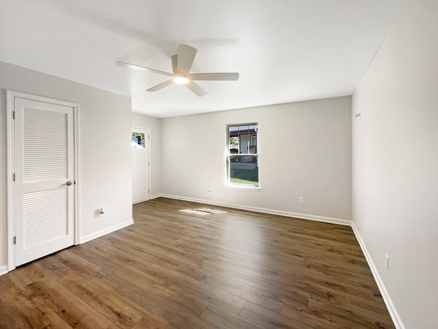 spare room featuring dark wood-type flooring and ceiling fan