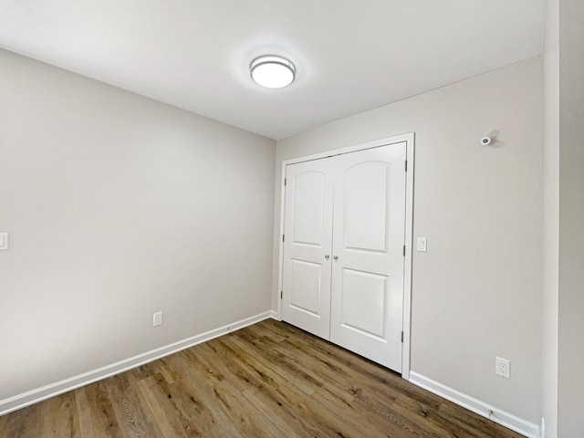 unfurnished bedroom featuring a closet and hardwood / wood-style floors