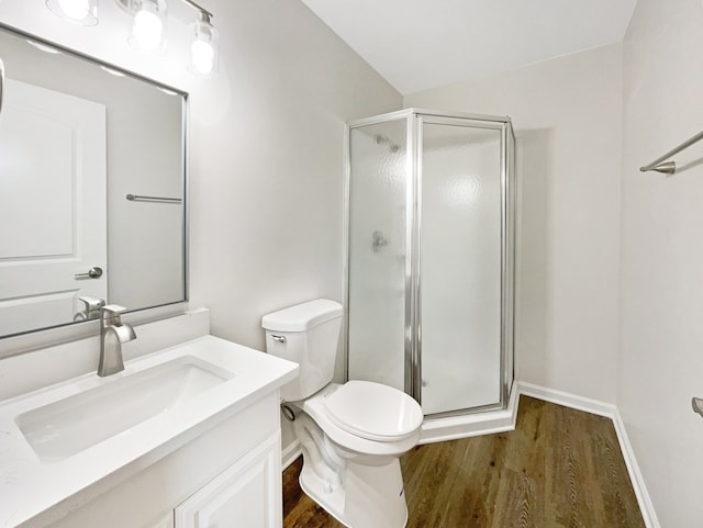 bathroom featuring walk in shower, vanity, hardwood / wood-style floors, and toilet