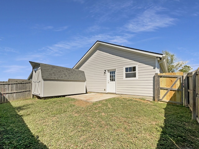 back of house featuring a shed, a yard, and a patio area