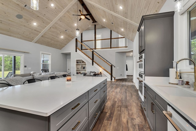 kitchen featuring gray cabinetry, high vaulted ceiling, a kitchen island, stainless steel appliances, and dark hardwood / wood-style floors