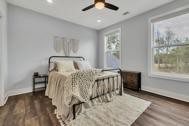 bedroom featuring multiple windows, dark wood-type flooring, and ceiling fan