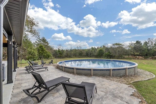 view of swimming pool with a patio area and a yard