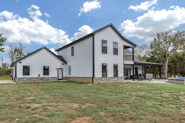 rear view of property with a yard and a patio area