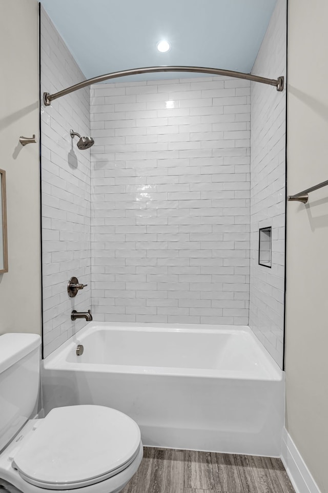 bathroom featuring toilet, lofted ceiling, tiled shower / bath, and hardwood / wood-style floors