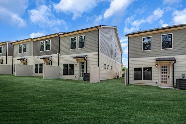 back of house featuring a lawn and cooling unit