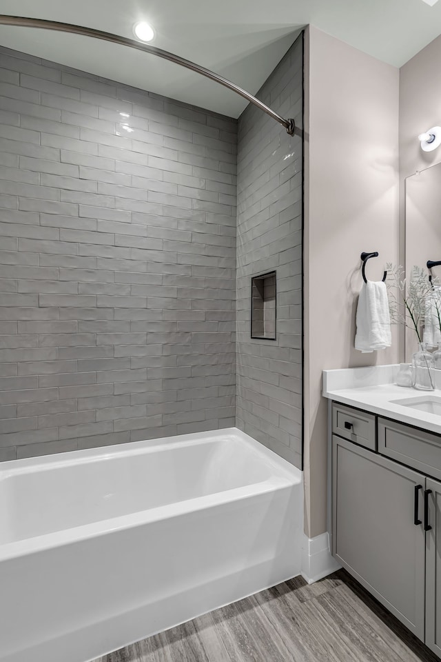 bathroom featuring vanity, tiled shower / bath combo, and hardwood / wood-style floors