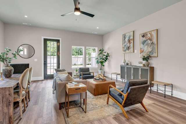 living room with ceiling fan and light wood-type flooring