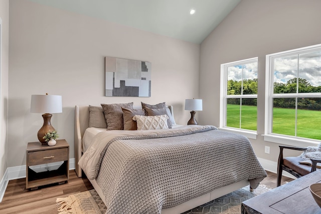 bedroom with light hardwood / wood-style flooring and high vaulted ceiling