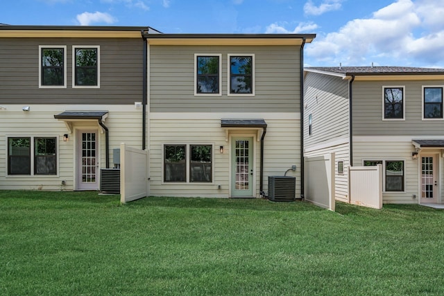 back of house featuring central air condition unit and a yard